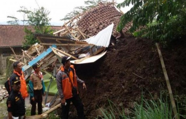 Petugas BPBD KBB berdiri di depan reruntuhan rumah warga yang hancur akibat tertimbun longsor di Perumahan Griya Utara Asabri RT 04/02 Kampung Cinangsi, Desa Karangtanjung, Kecamatan Cililin, KBB, Kamis (2/4/15). Sedikitnya 12 rumah hancur tertimbun longsor. ist 