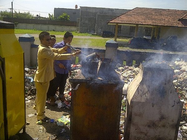 Ketua Fraksi Partai Golkar DPRD Kabupaten Bandung ikut membakar sampah yang menumpuk di Pasar Baleendah dengan menggunakan tungku pembakaran ajaib, Senin (25/7). by iwa/bbcom