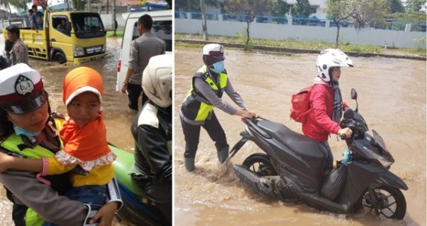 Para polwan cantik dari Polres Bandung membantu mendorong kendaraan bermotor pengendara yang menerjang genangan banjir di lokasi banjir depan pabrik Kahatex Rancakek, Senin (14/11). by bb8 