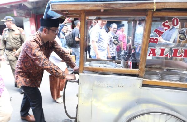 Wali Kota Bandung Ridwan Kamil mendorong gerobak bakso ke tempat relokasi eks PKL Jalan Ahmad Yani ke Pasar Kosambi, Sabtu (31/12). by Meiwan Humas Pemkot Bandung.