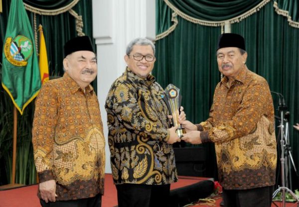 Gubernur Jabar Ahmad Heryawan menerima cindera mata dari Ketua PWRI Jabar Dani Setiawan dan Ketua Umum PB PWRI Haryono Suyono, saat peringatan Hari Jadi PWRI ke-55, di Aula Barat Gedung Sate Bandung, Jumat (29/9/17). by Humas Pemprov Jabar