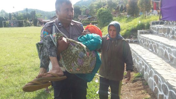 Personil Polsek Pasirjambu Aiptu Komang membopong Mak Min (80) untuk nyoblos Pilkades di TPS 6 Kampung Gambung RT 02 RW 08 Desa Mekarsari Kecamatan Pasirjambu, Kabupaten Bandung, Minggu (15/10/17). by bb80